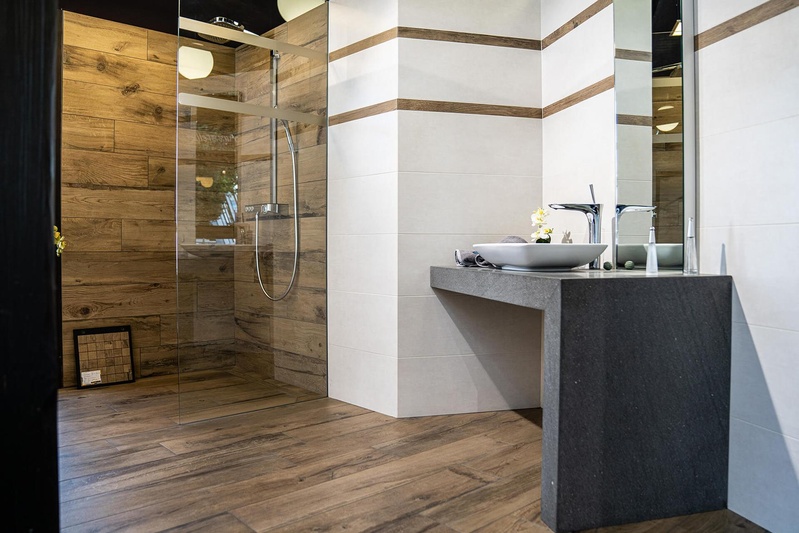 Badezimmer mit Wandfliesen in Holzoptik und cremefarbener Betonoptik, Ausstellung Pung Fliesen-Center Bonn